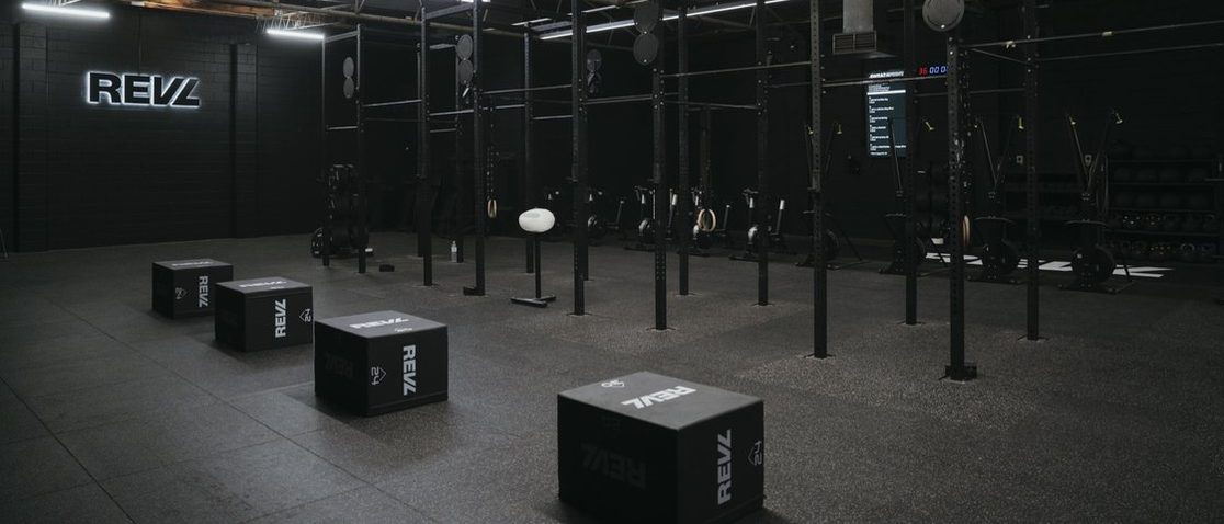 Inside a REVL Training studio, the REVL mark on the back wall
